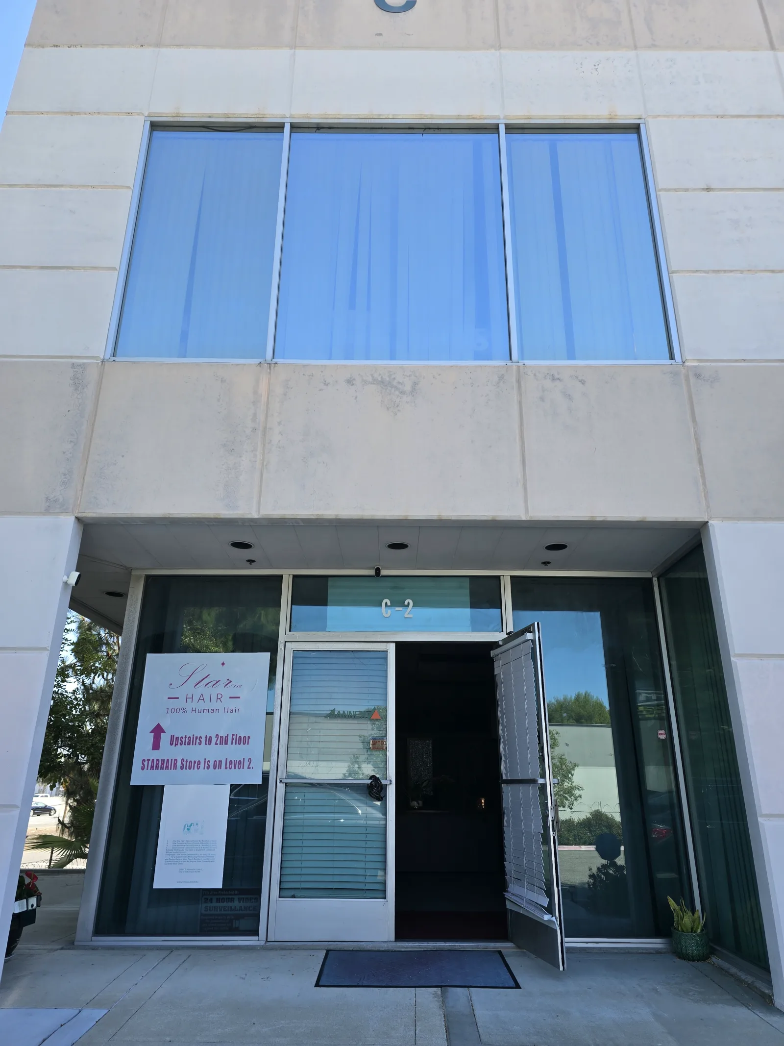 举办地临街入口,门口指示牌写明假发门店在二层